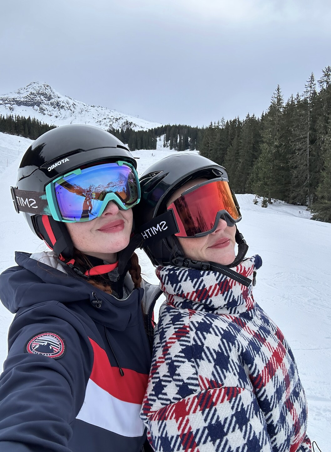 Lara and Skylar Dykstra in ski helmets and goggles on a snowy mountain
