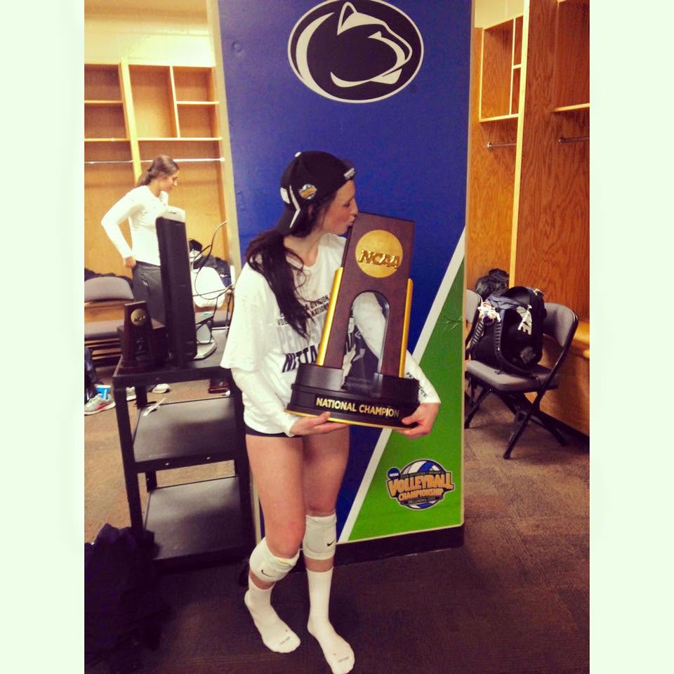 Skylar Dykstra holding the NCAA national champion trophy in the locker room